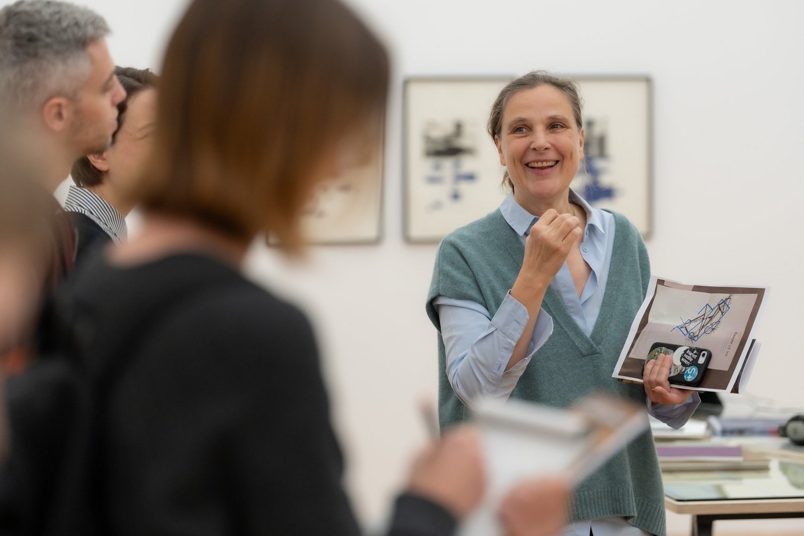 Frau mit Infomaterial spricht zu einer Gruppe im Museum