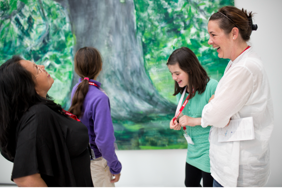 Vier junge Museumsbesucherinnen, die lachen und Spass haben