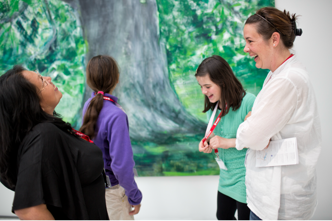 Vier junge Museumsbesucherinnen, die lachen und Spass haben