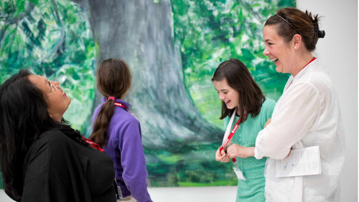 Vier junge Museumsbesucherinnen, die lachen und Spass haben