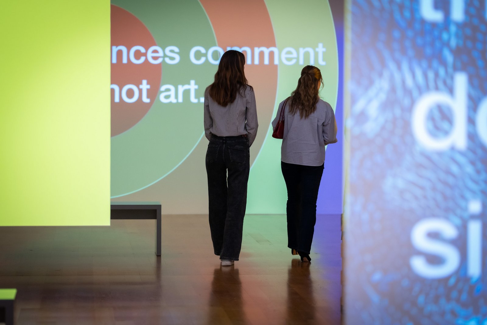 Zwei Frauen von hinten betrachten eine moderne Medien-Installation im Museum.