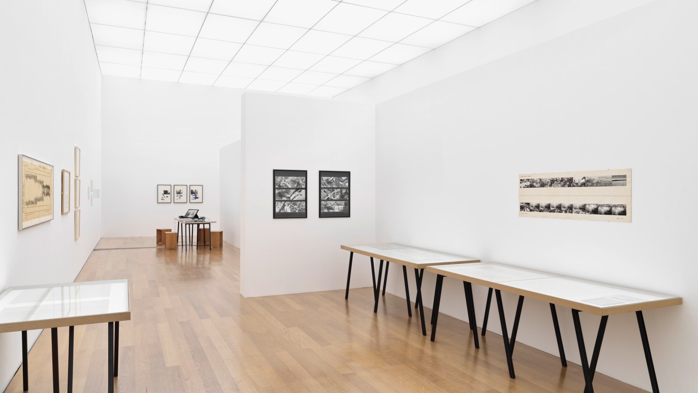 Ansicht des Ausstellungsraums mit verschiedenen Zeichnungen und Vitrinen