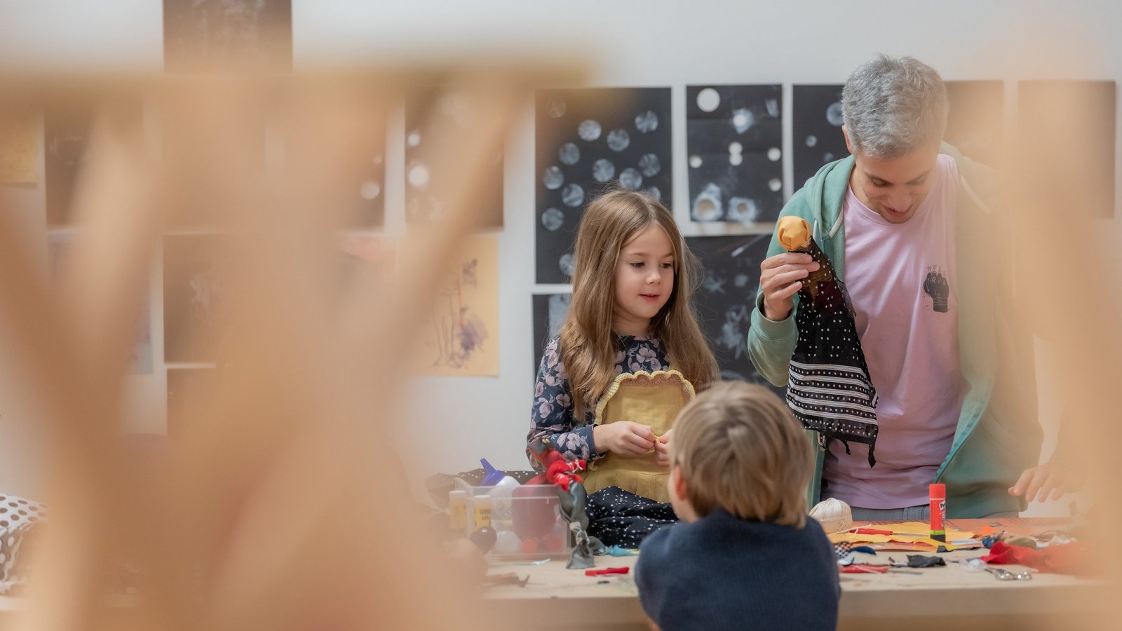 2 Kinder und ein Erwachsener basteln