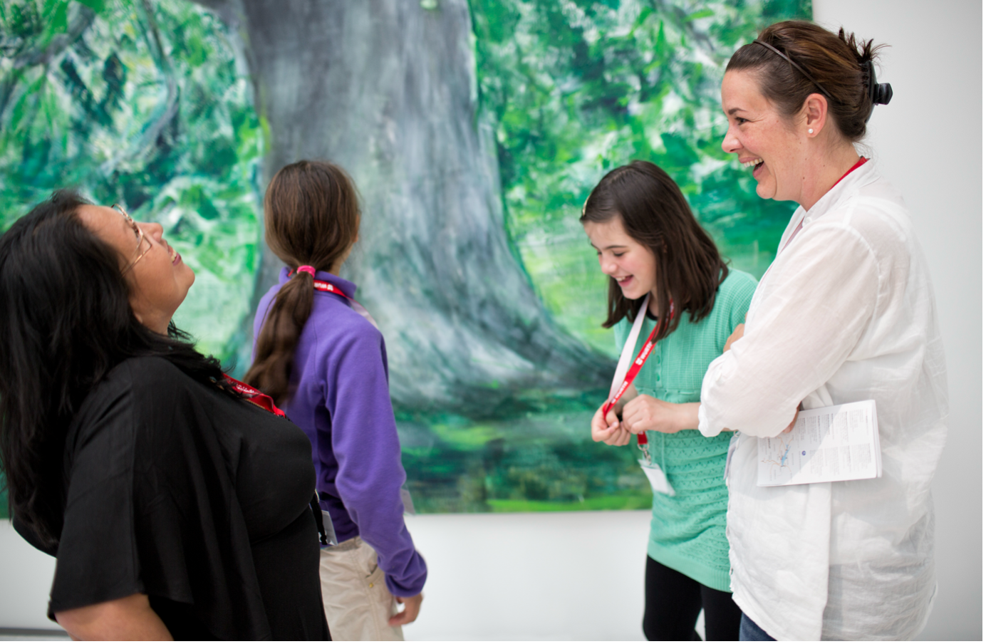 Vier junge Museumsbesucherinnen, die lachen und Spass haben
